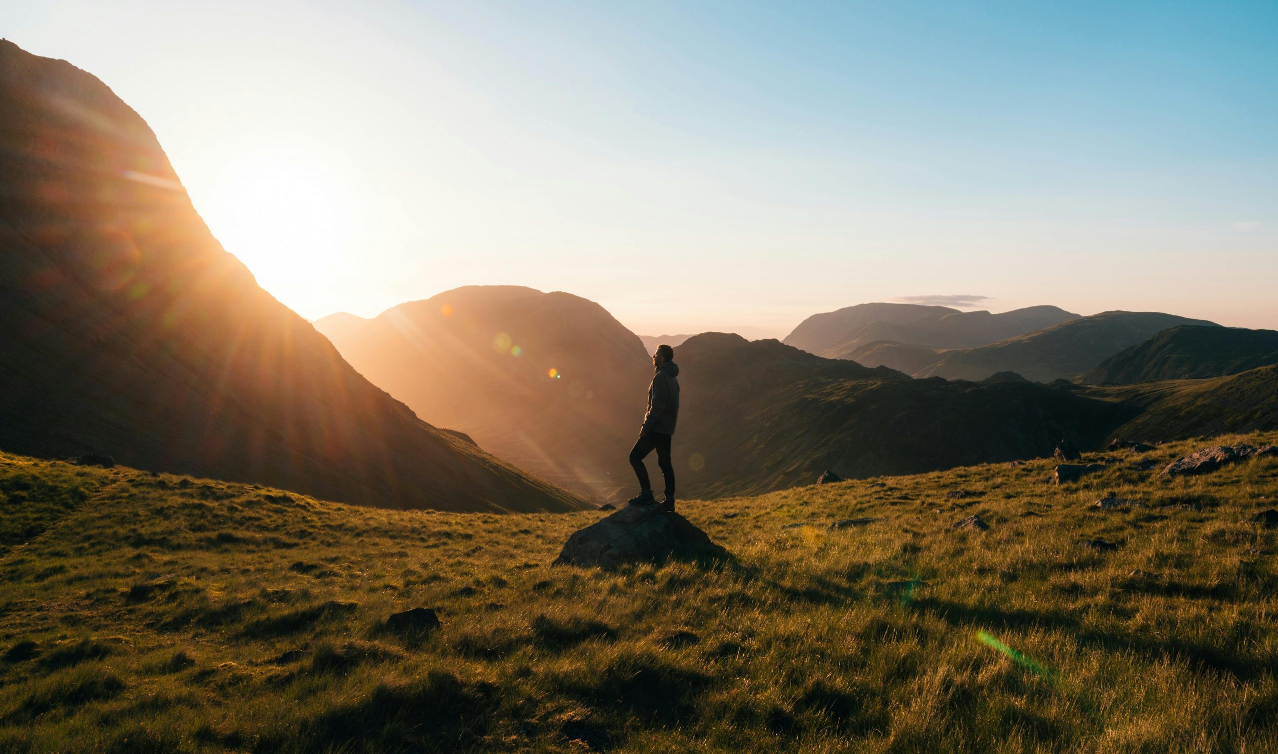 Photo by Simon Migaj: https://www.pexels.com/photo/silhouette-photography-of-person-standing-on-green-grass-in-front-of-mountains-during-golden-hour-746386/